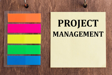 a card with text Project Management lying on a wooden background