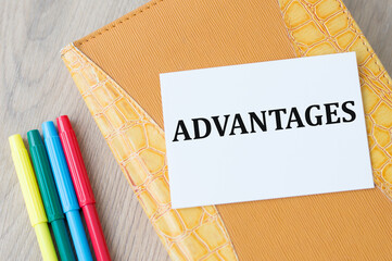 the text advantages on a card that lies on a notebook on a light background