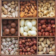 Assorted nuts in a wooden box. Set of almonds, peanuts, cashews, pistachios, macadamia, hazelnuts