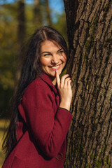 Portrait of a joyful young woman enjoying in the autumn park.