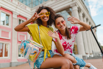 happy young girls friends smiling sitting in street