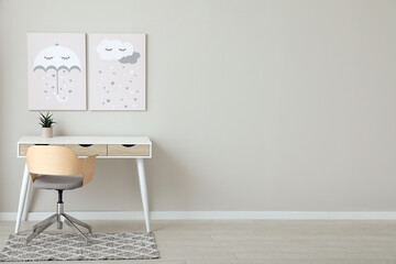 Children's room interior with desk, cute paintings and empty wall. Space for design