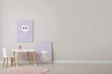 Children's room interior with table, cute paintings and empty wall. Space for design