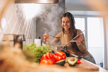 Woman cooking soup at kitchen