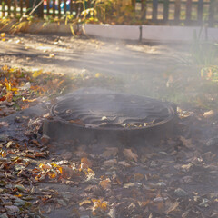Steam rises from the hot water manhole due to water leakage during an accident