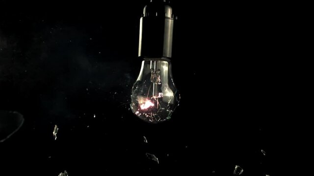 Super slow motion light bulb breaks into rattles. On a black background. Filmed on a high-speed camera at 1000 fps.High quality FullHD footage