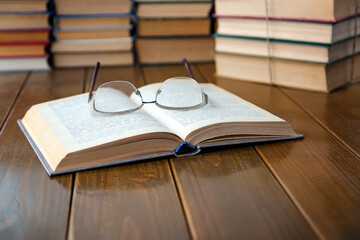 Open book, glasses on the table.