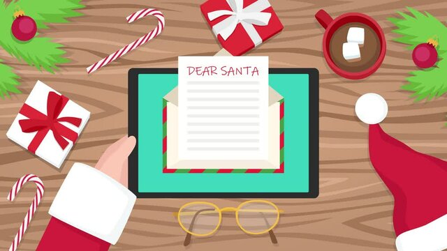4k video animation top view of Santa Claus holding tablet and opening email over christmas table. Santa is clicking envelope to open mail with kids letter. 