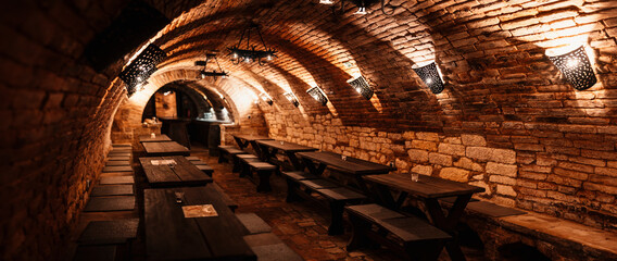 Old wine bottles dusting in an underground tratitional cellar. Small and old wine cellar with full...