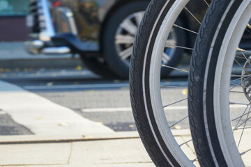 Bicycle wheel against the background of an automobile wheel. The concept of comparing bicycle and road transport.