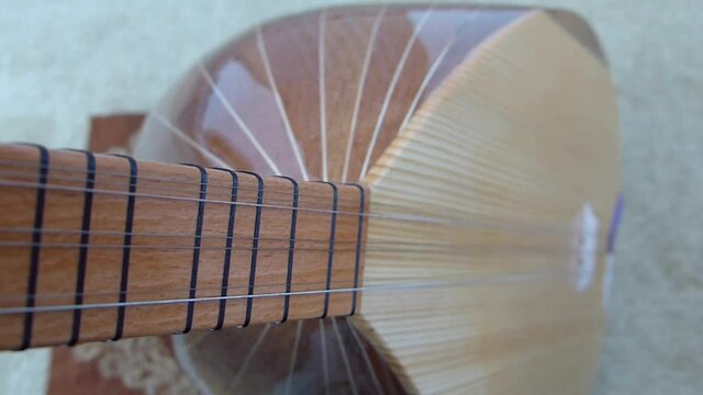 a musician is holding a saz, turkish musical instruments, close-up baglama, saz