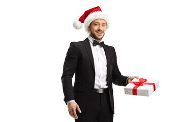 Elegant man wearing a santa claus hat and holding a gift box