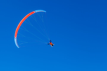Paragliding in the mountains, People paragliding tandem above mountain in winter in Dombay ski resort. Concept of active lifestyle and extreme sport adventure.