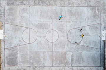Top down aerial view of cement basketball court