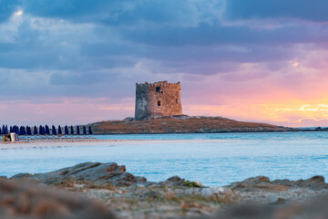 Stunning sunrise over the Aragonese Tower and La Pelosa Beach bathed by a calm turquoise water....