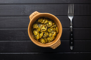 Pickled sliced jalapeno. Green jalapeno peppers in bowl.