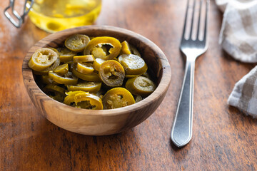 Pickled sliced jalapeno. Green jalapeno peppers in bowl.