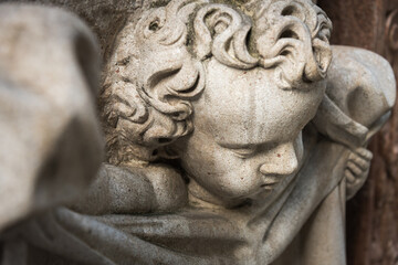 White sandstone sculpture of an angel wrapped in sheets