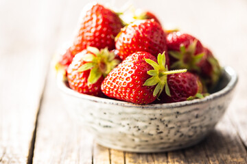 Whole ripe red strawberries in bowl.