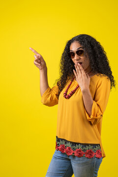 Mujer afroamericana sorprendida se&ntilde;alando a un lado  en un fondo amarillo