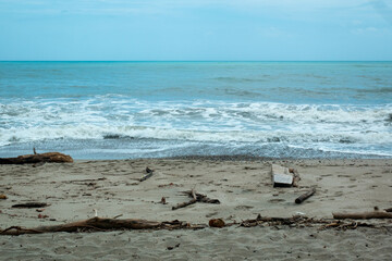 Waves of the Sea Reaching the Shore with Lots of Foam in a Cloudy and Cold Sky