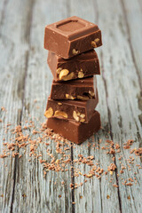 Five pieces of chocolate on wooden background.