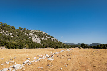 Hiking and trekking route, path, road in Mediterranean area with rocks, mountains, grass - adventure, outdoor, camping and hiking concept image taken in Lycian way trek in Turkey