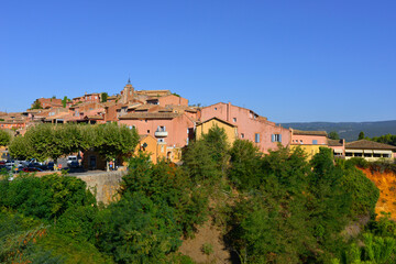 Roussillon (84220) habillé de rose entre ciel bleu et nature, département du Vaucluse en région Provence-Alpes-Côte-d'Azur, France