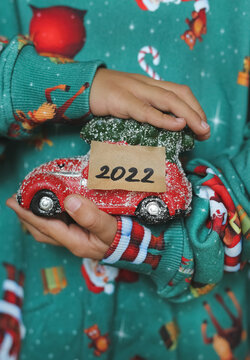a child holds a New Year's car in his hands with the year 2022 and dreams of a new toy