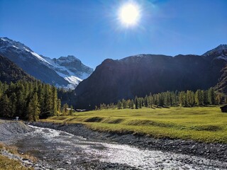 swiss mountain valley with mountain river and alps in the background,Davos,Sertig,Switzerland. autumn with colored larks