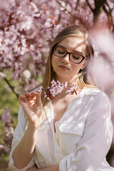 a girl looking at pink cherry blossom © ms16_photo