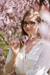 a girl wearing glasses holding a cherry blossom © ms16_photo