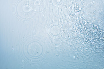 Fototapeta na wymiar Water blue background with circles from drops spreading in different directions, pattern, top view