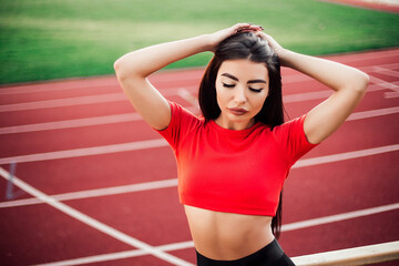 Fototapeta na wymiar Beautiful fitness woman in sportswear posing near running track.