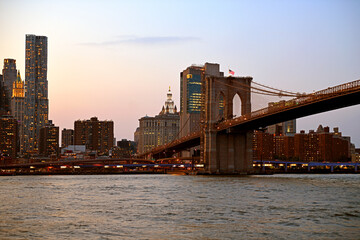 Brooklyn Bridge (1883), hybrid cable-stayed suspension bridge, at sunset in New York City. United...