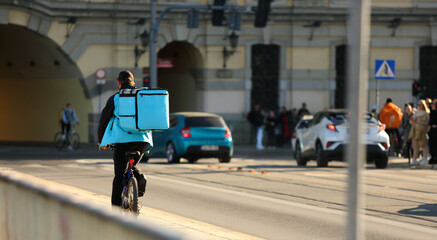 Kurier na rowerze, dostawa, smaczne jedzenie na ulicach miasta. - obrazy, fototapety, plakaty