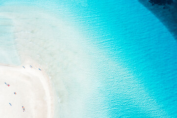 View from above, stunning aerial view of La Pelosa beach, a white sand beach bathed by a crystal clear water with beautiful shades of turquoise and blue. Stintino, Sardinia, Italy.