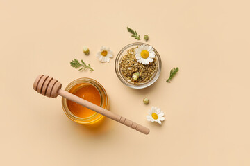 Composition with jar of sweet honey and dried chamomile flowers on color background