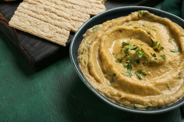 Bowl with tasty baba ghanoush and crackers on color background, closeup