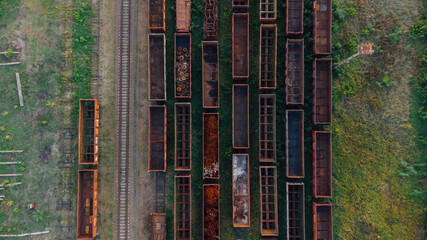 Obraz premium Aerial View. Old defective and looted railway wagons stand on the territory of the repair depot awaiting repairs. Poor business management. Ukrainian railway, DVRZ.