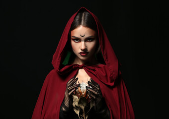 Beautiful woman dressed as witch for Halloween on dark background