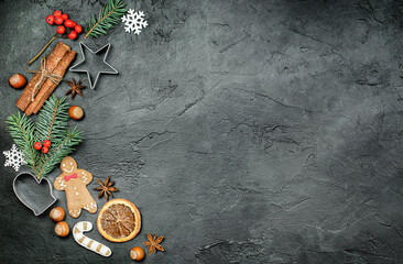 christmas decorations, gingerbread and cookie cutters on dark background
