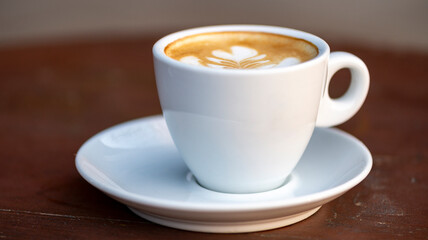 White cup of espresso coffee on wooden table. Space to copy your text.