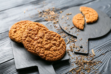 Boards with tasty hojicha cookies on black wooden background