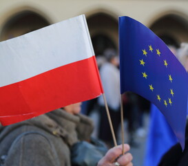 flags of european countries and Poland hold by protesting woman during demonstration to support Polands membership in EU