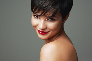 Portrait of beautiful young woman with short hair and red lipstick on her lips isolated on studio...