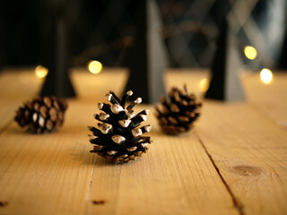 Pine cones on wooden table at Christmas with bokeh lights