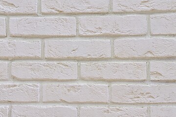 White fresh-painted surface of brickwork facade of old renovated building. White brick wall background. Texture of whitened brick wall close-up.