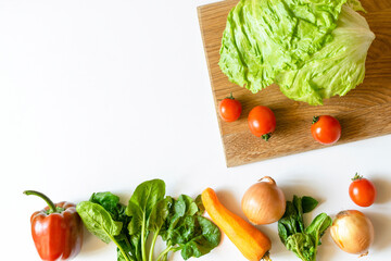 Organic and bio fresh vegetables on cutting desk, on white background table with copy space. Healthy natural ripe vegetarian vegetables concept. Salad ingredients lies in row
