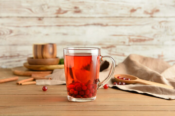 Cup of hot cranberry tea on wooden table